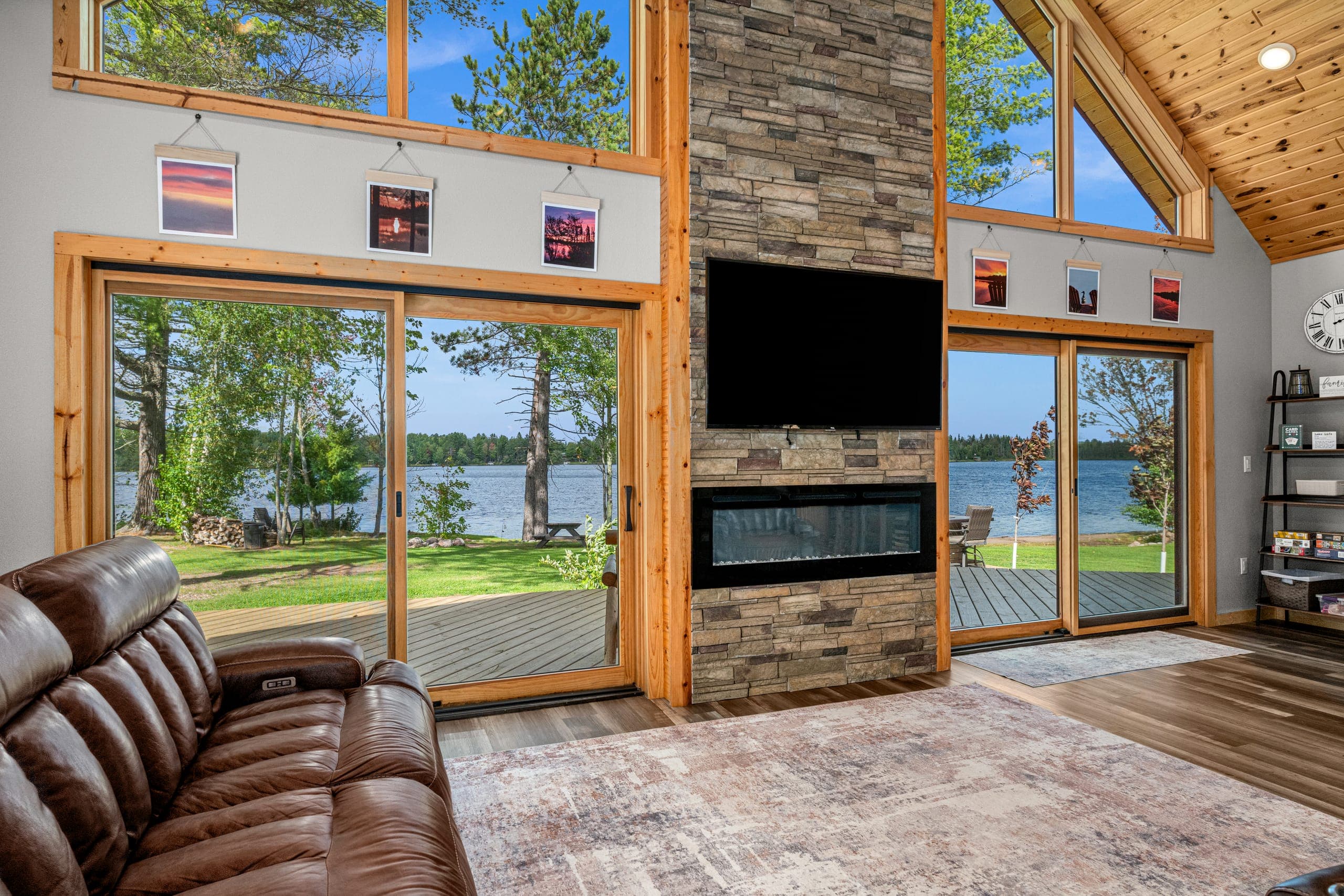 Great room with a stone fireplace and sliding doors to the lake