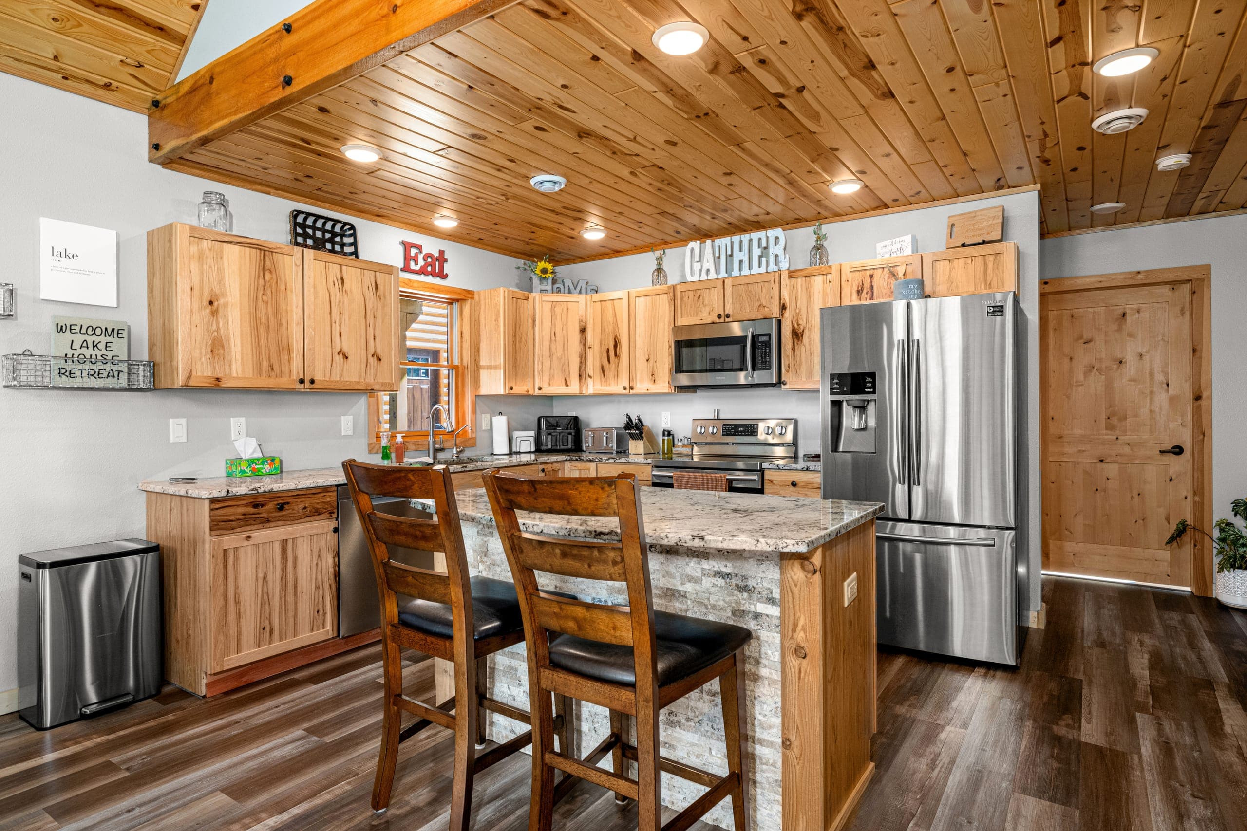 Kitchen island with stools and knotty pine cabinets
