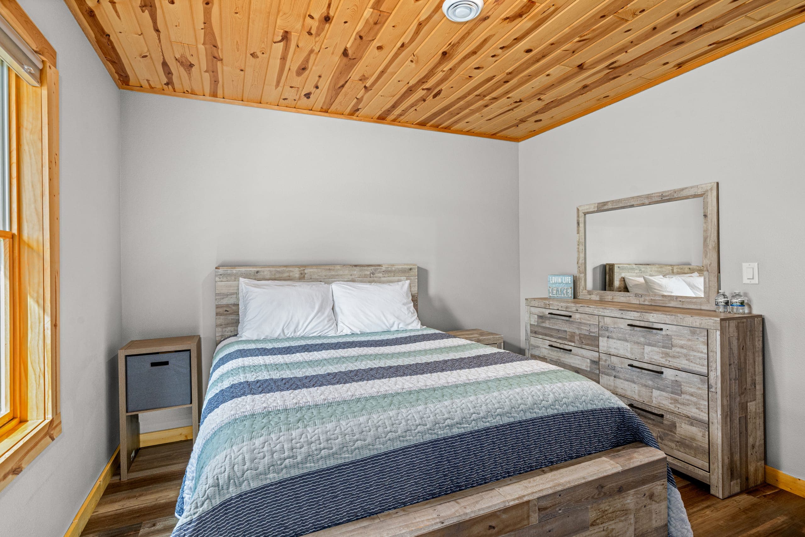 Queen bedroom with a wood dresser and mirror