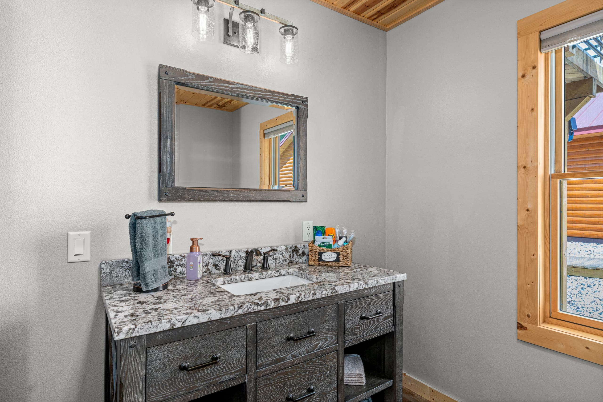 Bathroom vanity with a wood-framed mirror