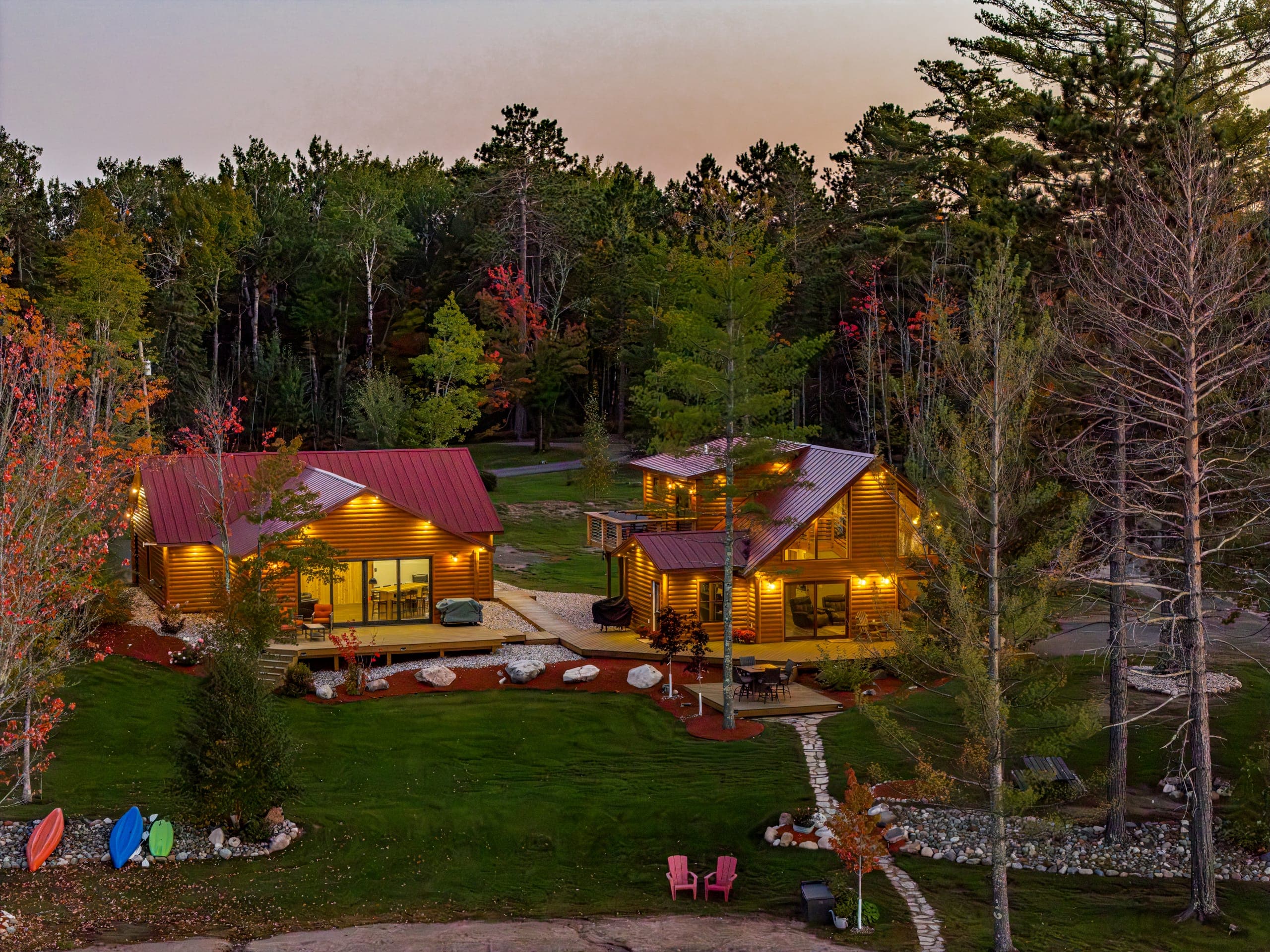 Close aerial of the two cabins lit up at dusk