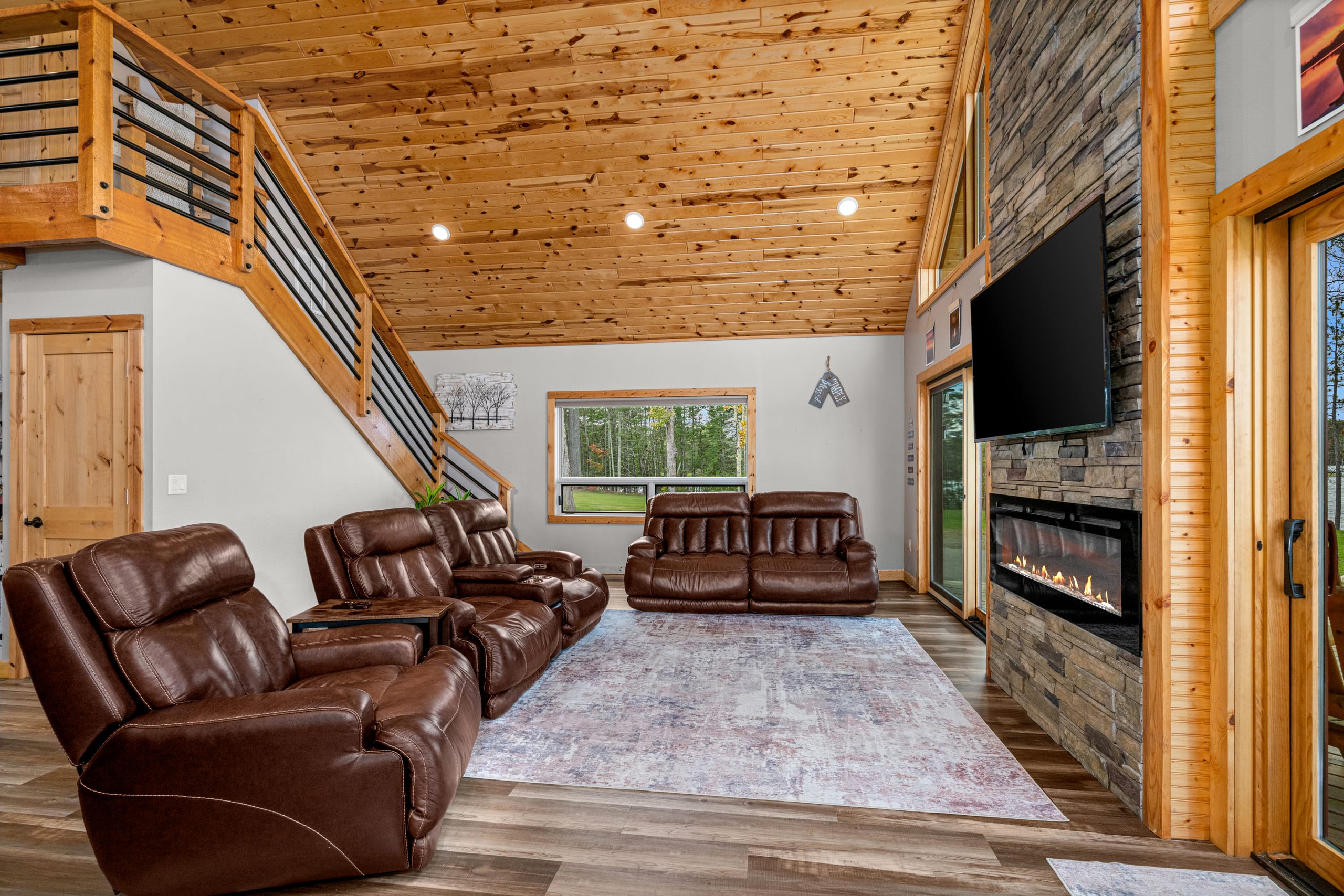 Living room with the fireplace lit under the loft